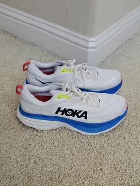 Hoka Bondi 8 White Sneakers with Blue Midsole and Red Heel Tabs.